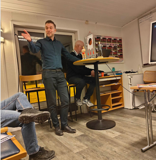 Kassör Niklas Andersson presenterar med Bengt Alfredsson i bakgrunden.